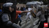 Polisi berusaha menghalau massa aksi untuk mencegah kericuhan meluas dan tidak terkendali. Demo massa PMII di Gedung Merah Putih KPK berjalan sejak siang, selepas salat Jumat. (CNN Indonesia / Adhi Wicaksono).