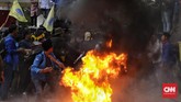 Tak puas melempar telur, massa dari PMII membakar ban bekas di depan Gedung Merah Putih. Api berkobar cukup besar. Polisi bereaksi dengan mendatangi lokasi ban terbakar untuk memadamkan api. (CNN Indonesia / Adhi Wicaksono).