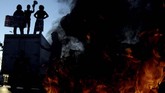 Sejumlah mahasiswa Universitas Hasanuddin (Unhas) Makassar membakar ban saat berunjuk rasa di depan kampus Unhas Makassar, Sulawesi Selatan, Senin (23/9). (ANTARA FOTO/Abriawan Abhe).