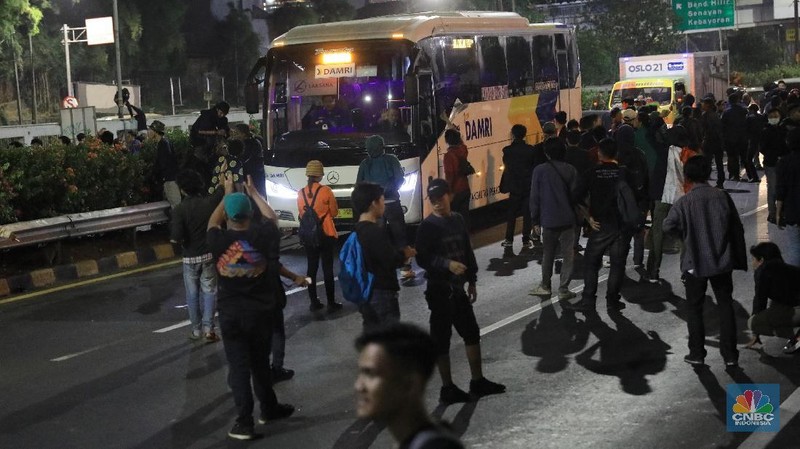 Mobil-mobil yang berada di dalam tol terjebak, sementara massa di depan gedung DPR masih bertahan.