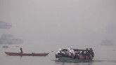 Sejumlah siswa menaiki kapal motor menembus kabut asap akibat kebakaran lahan di Sungai Ogan, Palembang, Sumatera Selatan, Senin (16/9). Kabut asap akibat karhutla telah mengganggu aktivitas masyarakat. ANTARA FOTO/Mushaful Imam