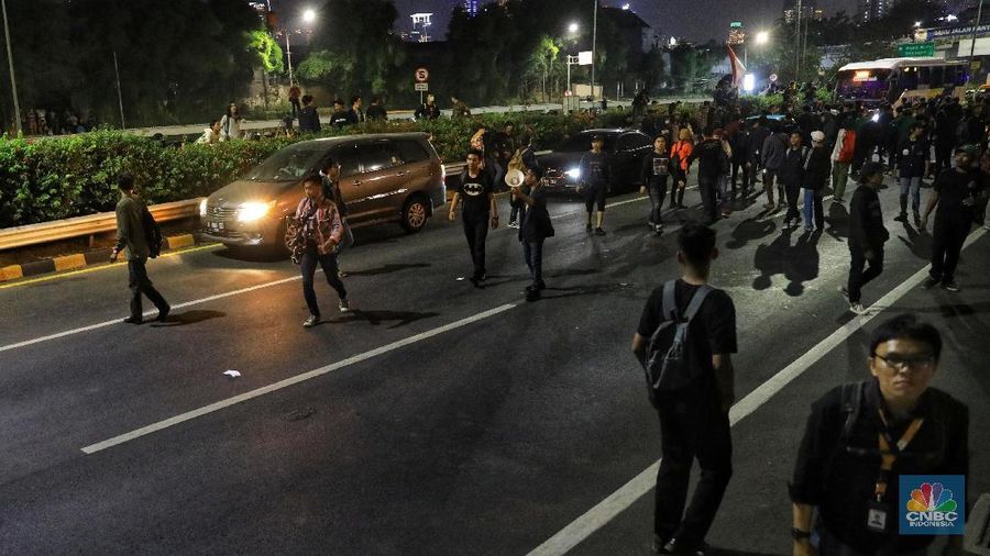 Mobil-mobil yang berada di dalam tol terjebak, sementara massa di depan gedung DPR masih bertahan.