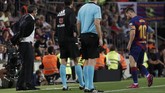 Lionel Messi berjalan ke pinggir lapangan untuk menerima perawatan tim medis dengan pelatih Barcelona Ernesto Valverde melihat ke arah La Pulga. (AP Photo/Joan Monfort)