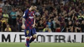 Lionel Messi berjalan ke dalam lapangan dengan masih mengeluh sakit pada bagian paha kiri. Messi tetap mampu melanjutkan pertandingan usai mendapat perawatan tim medis. (AP Photo/Joan Monfort)