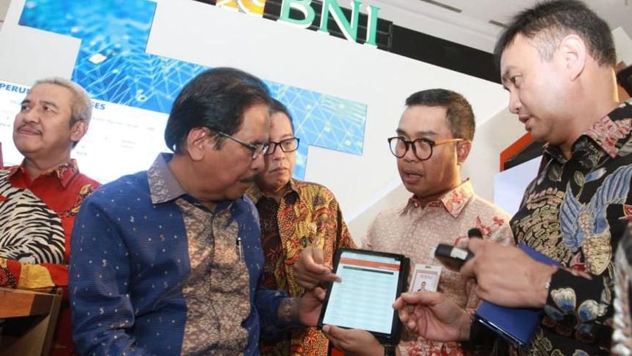 Menteri Agraria dan Tata Ruang Indonesia Sofyan Djalil (kedua kiri) mendengarkan penjelasan mengenai aplikasi online (e-Form) KPR BNI Griya