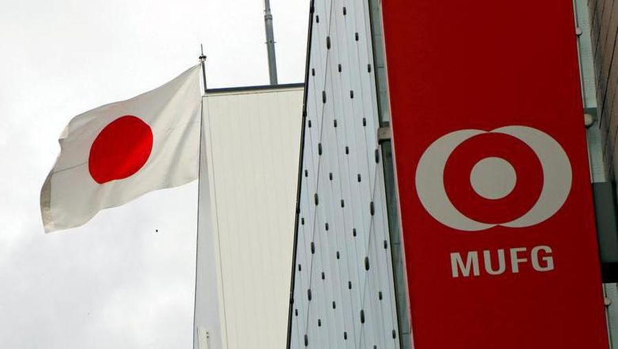 FILE PHOTO: Japan's national flag is seen behind the logo of Mitsubishi UFJ Financial Group Inc (MUFG) at its bank branch in Tokyo, Japan September 5, 2017. REUTERS/Kim Kyung-Hoon/File Photo