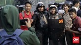 Saat melakukan pengamanan aksi massa pelajar sekolah menengah di belakang Gedung DPR, polisi mencoba ajakan persuasif lewat pengeras suara dengan mengingatkan hormat kepada yang lebih tua dan hindari provokasi. (CNN Indonesia/Adhi Wicaksono)