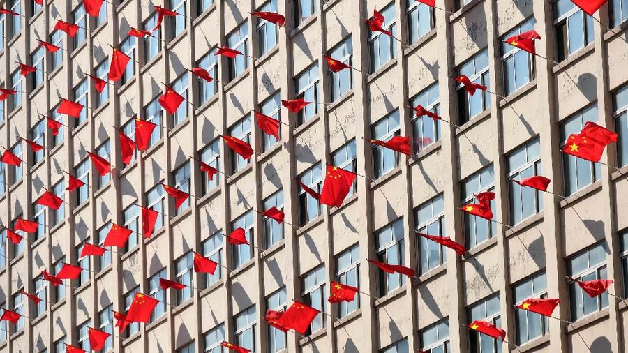 Chinese flags hang outside windows of a building at a university ahead of the 70th founding anniversary of People's Republic of China in Shenyang, Liaoning province, China September 26, 2019. REUTERS/Stringer ATTENTION EDITORS - THIS IMAGE WAS PROVIDED BY A THIRD PARTY. CHINA OUT.