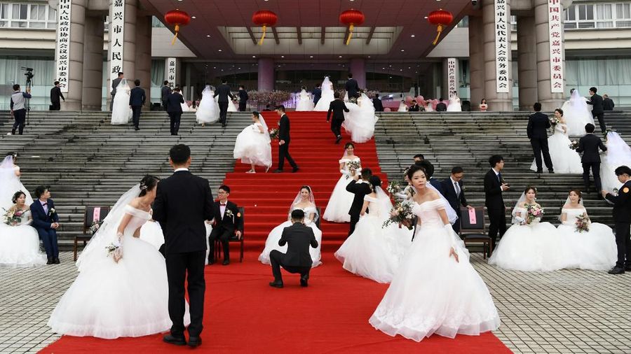 Couples attend a mass wedding at the city's municipal government building ahead of the 70th founding anniversary of People's Republic of China in Jiaxing, Zhejiang province, China September 22, 2019. REUTERS/Stringer ATTENTION EDITORS - THIS IMAGE WAS PROVIDED BY A THIRD PARTY. CHINA OUT.     TPX IMAGES OF THE DAY
