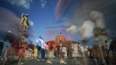 Pada suatu hari yang terik di kota Roma, Italia, para wisataman berjalan di jembatan Sant'Angelo yang menuju kastil Sant'Angelo atau dikenal juga dengan nama Mausoleum Hadrian. (AP Photo/Andrew Medichini)