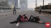 Jalan tol kemudian ditutup oleh petugas. Kerusuhan kemudian pecah saat massa melempari petugas yang kemudian dibalas dengan tembakan gas air mata dan semprotan air. (CNN Indonesia/Safir Makki)