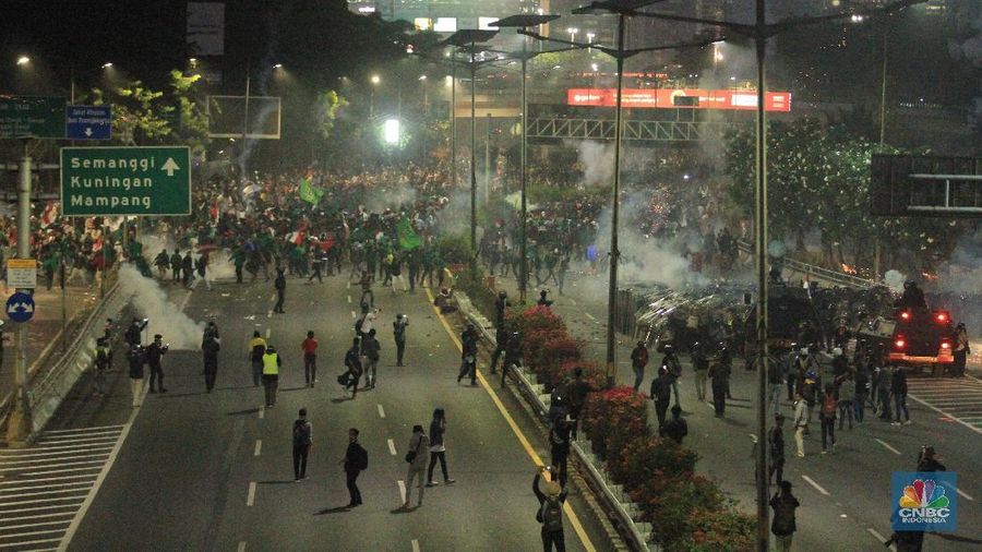 Aksi saling serang terjadi antara massa dan petugas kepolisian.