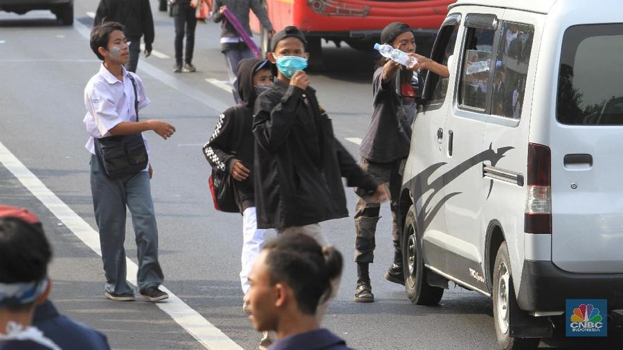 Massa yang mayoritas berseragam putih abu-abu bergerak ke bagian belakang DPR.