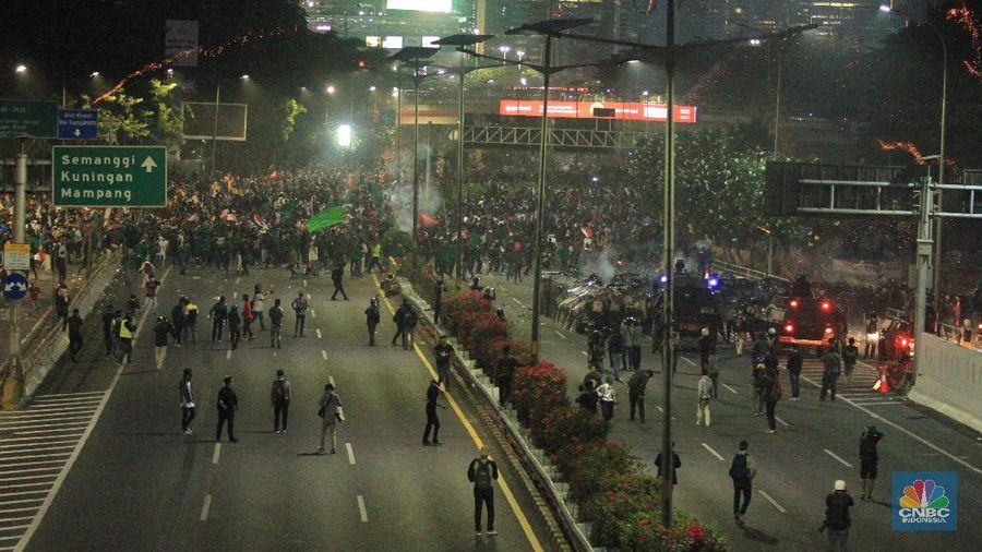 Aksi saling serang terjadi antara massa dan petugas kepolisian.