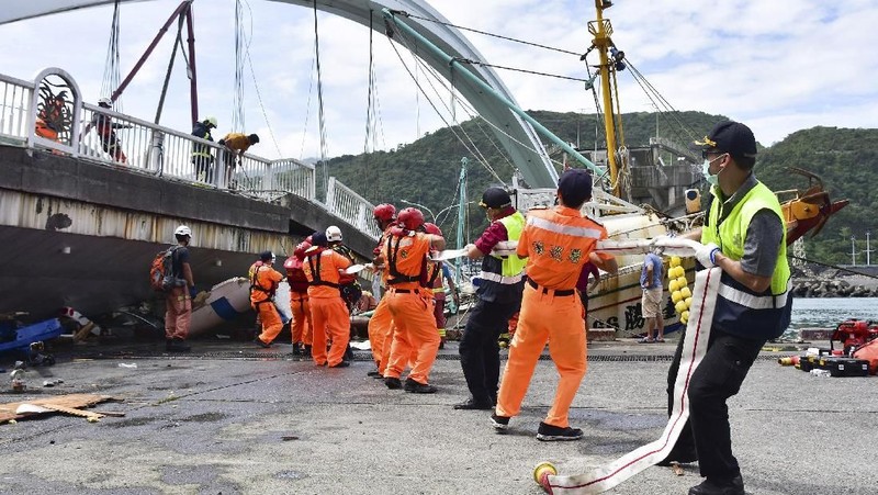 Penyelam bergabung dengan ratusan penyelamat dalam upaya pencarian, menggunakan crane dan excavator untuk mengangkat puing-puing perahu nelayan