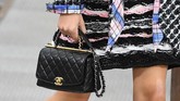 Microbag Chanel yang dipadukan dengan busana aneka warna dasar elegan Chanel masih terasa kuat dalam koleksinya. (Christophe ARCHAMBAULT / AFP)