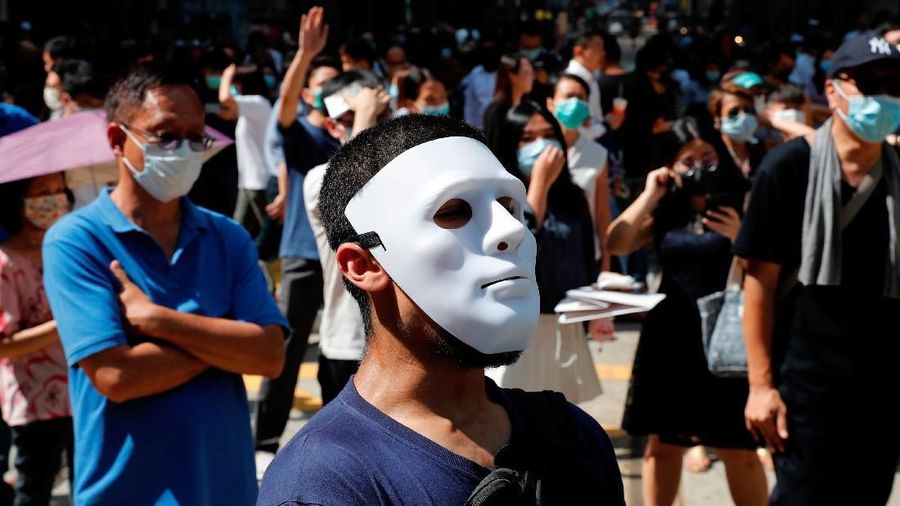 Dalam aksinya, para demonstran kompak memakai masker untuk menutupi identitas mereka.
