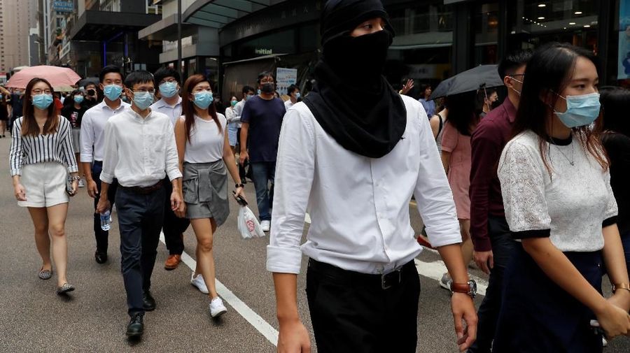Dalam aksinya, para demonstran kompak memakai masker untuk menutupi identitas mereka.
