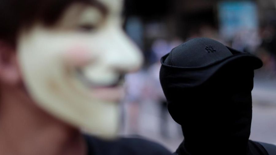 Dalam aksinya, para demonstran kompak memakai masker untuk menutupi identitas mereka.
