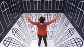 Seorang pengunjung menjajal ruang interaktif bernama 'Anamorphic Room'. (AP Photo/Jens Meyer)