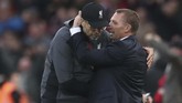 Pelatih Leicester City Brendan Rodgers berpelukan dengan pelatih Liverpool Juergen Klopp usai laga. Kemenangan membuat Liverpool masih sempurna di Liga Inggris dengan koleksi 24 poin, unggul delapan poin dari Manchester City. (AP Photo/Jon Super)