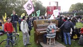 Unjuk rasa menentang perubahan iklim dilakukan dengan berbagai cara. Salah satunya dengan sambil bermain piano seperti yang dilakukan di Parc de la Vilette ,Paris, Prancis. (Photo by JACQUES DEMARTHON / AFP)