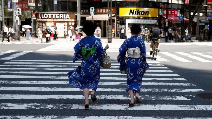 FILE PHOTO: Girls wearing the yukata, or casual summer kimono, run as they cross the road at a shopping district in Tokyo, Japan, July 20, 2018. REUTERS/Kim Kyung-Hoon/File Photo