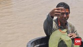 Kandi (35), warga Muara Sungai Kelese menunjukkan manik-manik diduga sisa harta Sriwijaya temuannya yang sudah berbentuk untaian. (CNN Indonesia/Hafidz Trijatnika)