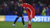 Gareth Bale terlihat mengeluh sakit pada bagian kaki kiri saat laga Wales vs Kroasia. Bale dan Modric berpeluang absen memperkuat Real Madrid melawan Barcelona di El Clasico. (GEOFF CADDICK / AFP)