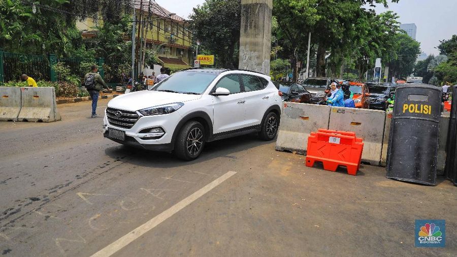 Personel kepolisian berjaga di Jalan Gatot Subroto, Jakarta Pusat, arah depan gedung DPR/MPR.