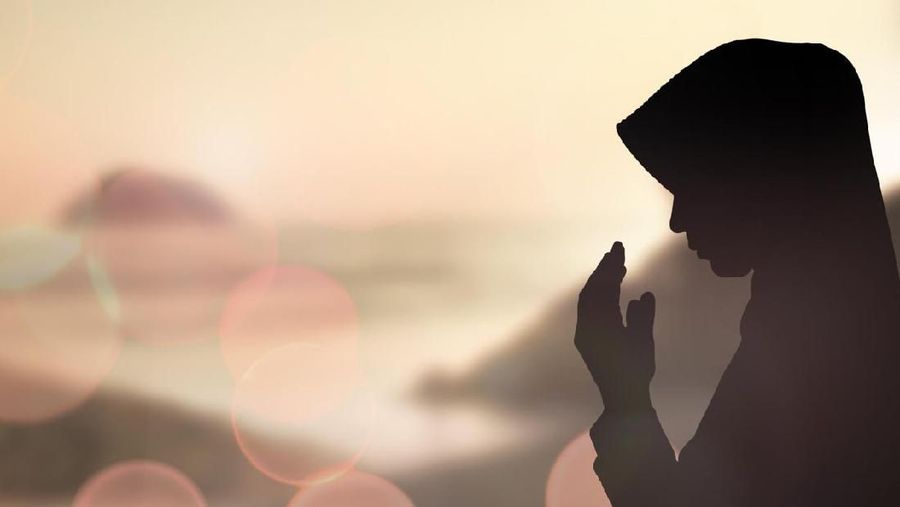Woman hands praying for blessing from god on sunset background