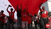 Relawan mengibarkan bendera sepanjang 200 meter untuk pawai menyambut pelantikan Jokowi menjadi Presiden di periode kedua. (CNN Indonesia/Safir Makki)