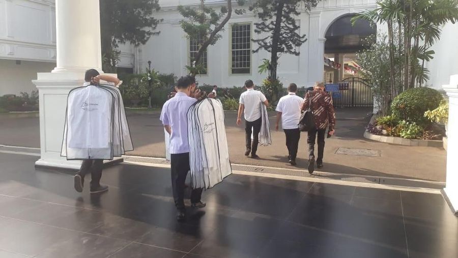 Sejumlah petugas membawa kemeja putih berlengan panjang yang masih terbungkus dengan rapih.