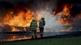 Petugas pemadam kebakaran menggunakan cairan kimia untuk memadamkan api. Objek yang terbakar adalah bahan bakar minyak sehingga harus menggunakan cairan khusus untuk memadamkan api yang bersumber dari minyak. (ANTARA FOTO/Raisan Al Farisi)