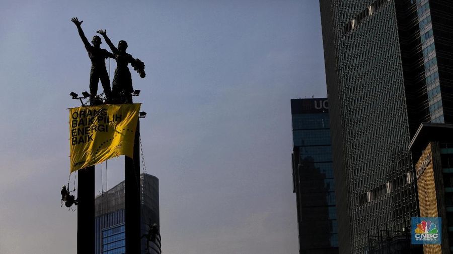 Greenpeace menyuarakan tuntutan mereka pada pemerintah dengan mengibarkan spanduk di patung ikonik Jakarta.