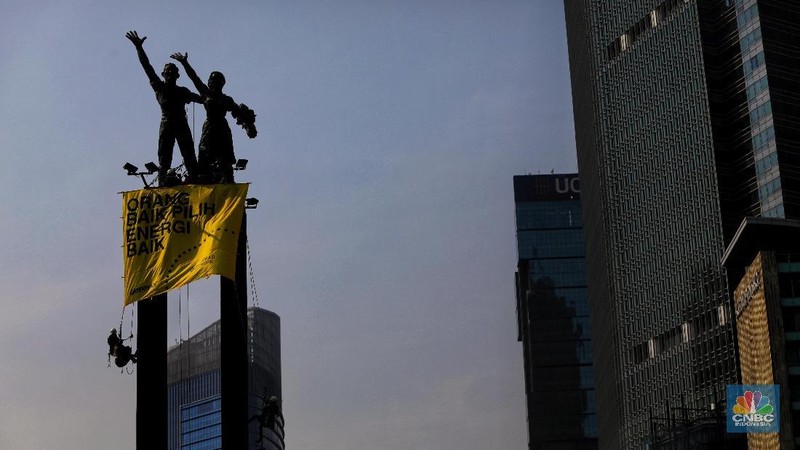 Greenpeace menyuarakan tuntutan mereka pada pemerintah dengan mengibarkan spanduk di patung ikonik Jakarta.