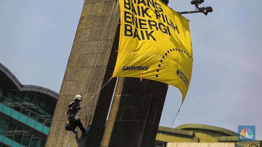 Greenpeace menyuarakan tuntutan mereka pada pemerintah dengan mengibarkan spanduk di patung ikonik Jakarta.