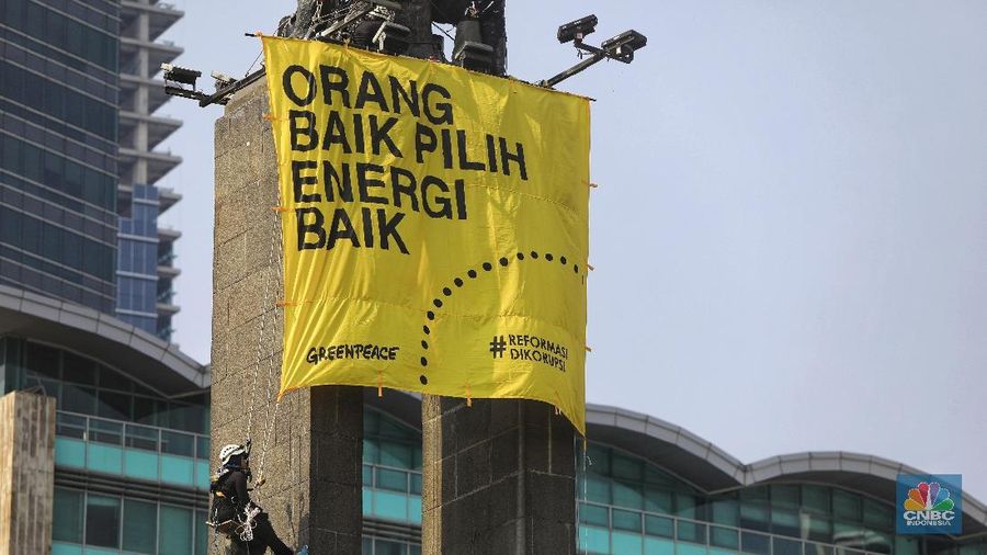 Greenpeace menyuarakan tuntutan mereka pada pemerintah dengan mengibarkan spanduk di patung ikonik Jakarta.
