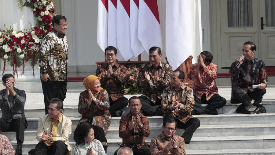 Newly appointed Defense Minister Prabowo Subianto, center, walks past Indonesian President Joko Widodo, seated left, his former rival in last April's election and Vice President Ma'ruf Amin, seated right, during the announcement of the new cabinet ministers at Merdeka Palace in Jakarta, Indonesia, Wednesday, Oct. 23, 2019. (AP Photo/Dita Alangkara)