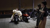 Di Oita, Jepang, para pejalan melihat seorang penggemar rugbi berdandan sebagai pegulat sumo. (AP Photo/Christophe Ena)