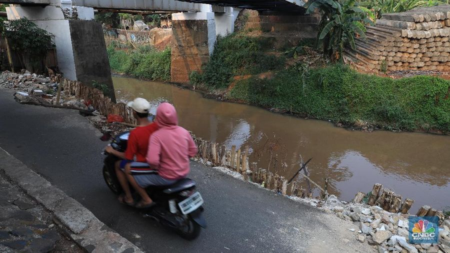 Sebagian jalan sudah tergerus oleh air kali dan hanya di tahan oleh beberapa kayu atau balok di sekitar.