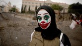 Seorang perempuan Lebanon yang wajahnya dipulas oleh karakter Joker turut serta dalam aksi protes di Beirut. (Photo by Patrick BAZ / AFP)