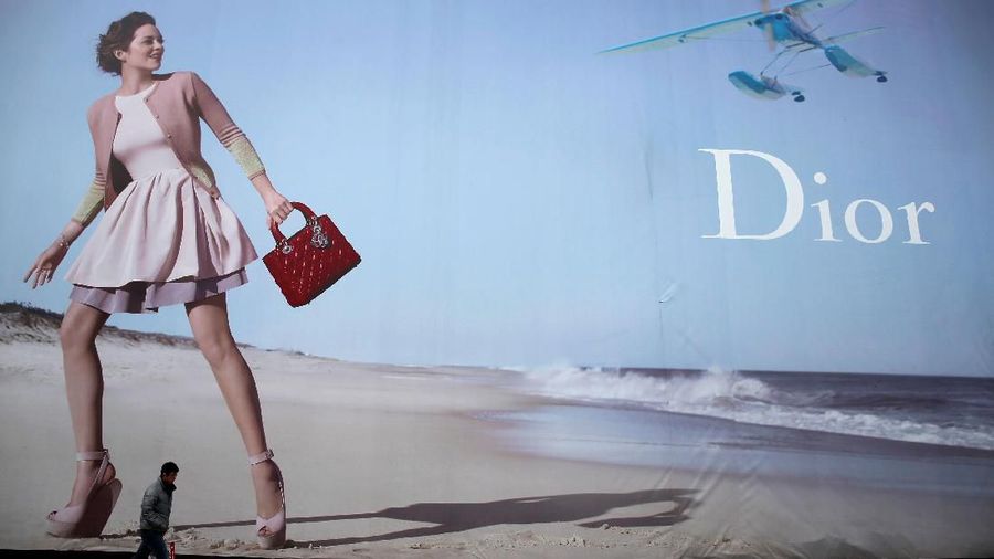 FILE PHOTO: A man walks past a Dior advertisement outside a shopping mall in Wuhan, Hubei province, January 19, 2013. REUTERS/Stringer/File Photo CHINA OUT. NO COMMERCIAL OR EDITORIAL SALES IN CHINA.