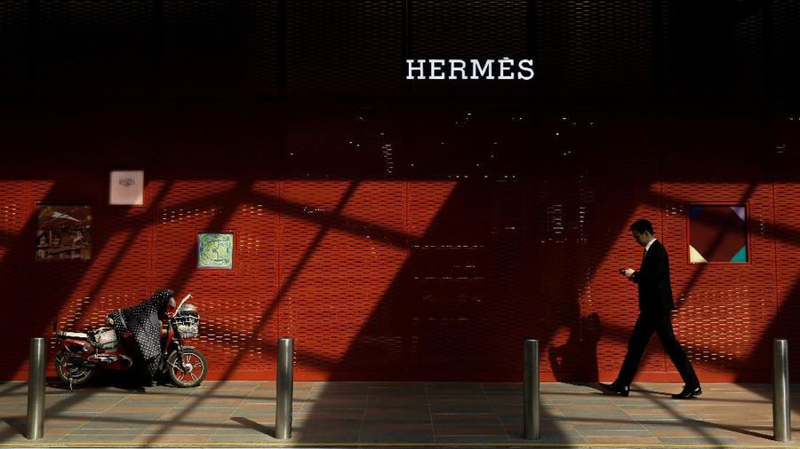 FILE PHOTO: A man walks past a store of luxury goods retailer Hermes one day before the opening session of the National People's Congress (NPC) in Beijing, China March 4, 2019. REUTERS/Thomas Peter/File Photo