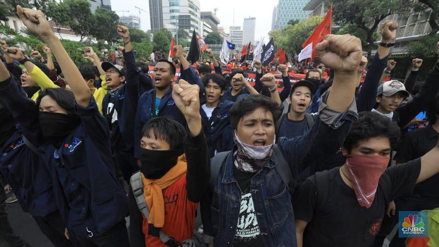 Massa membawa bendera Indonesia dan spanduk bertuliskan kritik untuk Presiden Joko Widodo dan Wakil Presiden Ma'ruf Amin.