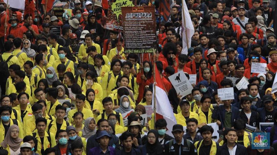 Massa membawa bendera Indonesia dan spanduk bertuliskan kritik untuk Presiden Joko Widodo dan Wakil Presiden Ma'ruf Amin.