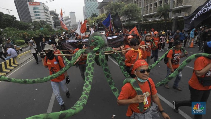Massa membawa bendera Indonesia dan spanduk bertuliskan kritik untuk Presiden Joko Widodo dan Wakil Presiden Ma'ruf Amin.