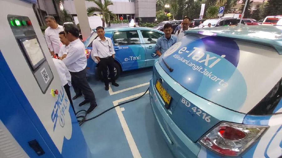 Vice Presiden Public Relation PLN, Dwi Suryo Abdullah (kanan) didampingi  EVice Presiden Perencanaan Korporat PLN, Rawan Insani, (paling kiri) saat mencoba charge kendaraan taxi di Stasiun Pengisian Kendaraan Listrik Umum (SPKLU) di PLN Pusat, Jakarta Selatan, Senin (28/10). (Dok. PLN)