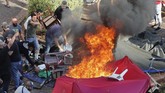 Pendukung Hizbullah kemudian membakar tenda-tenda yang digunakan para demonstran untuk menutup jalanan di Ibu Kota Beirut. (AP Photo/Hussein Malla)