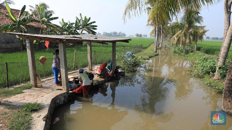 Warga memanfaatkan air sungai untuk mencuci saat musim kemarau berkepanjangan tiba.